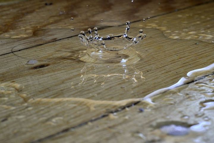 Water pooling and splashing on a wooden floor